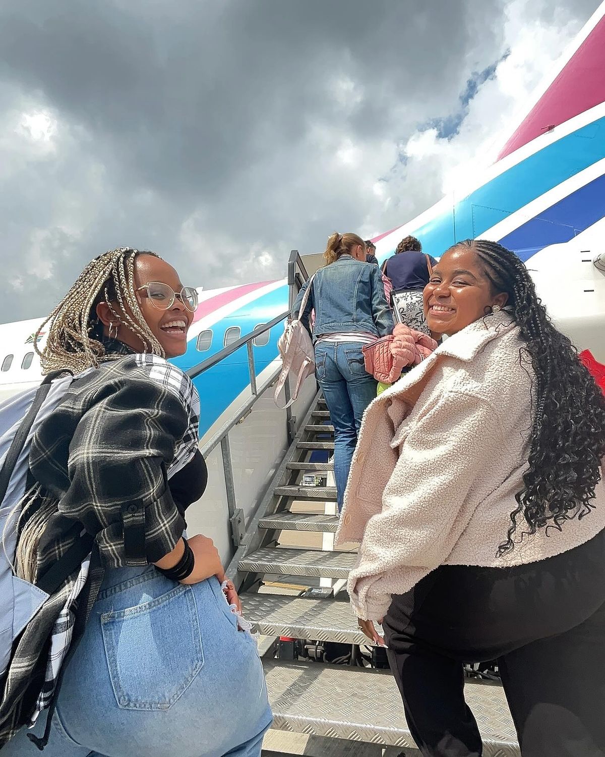 Voyageuses souriantes embarquant à bord d'un avion pour leur voyage